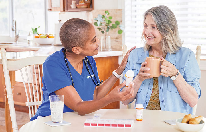 A CenterWell Home Health clinician discusses medications with a patient in her home
